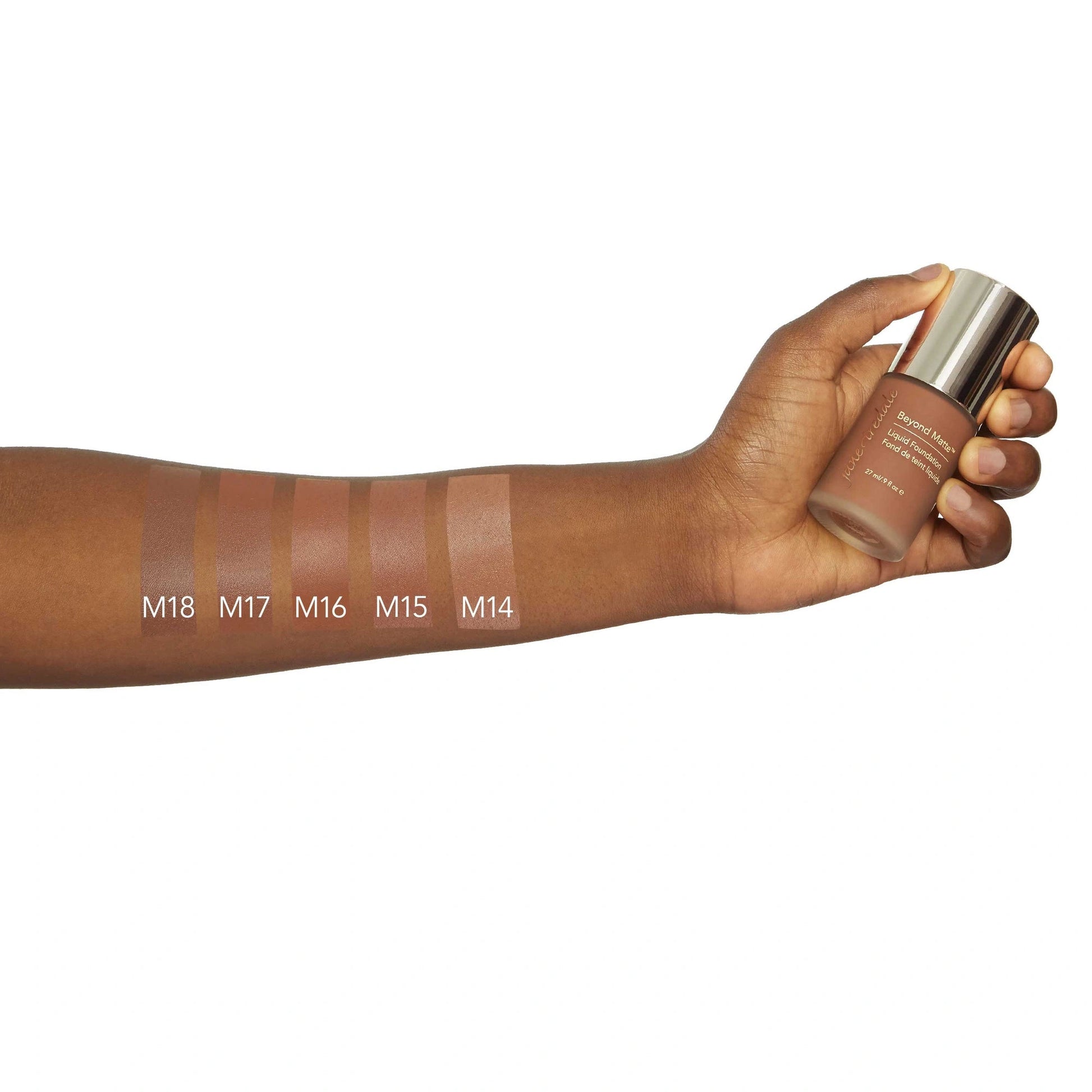 Jane Iredale Beyond Matte Liquid Foundation M18 in hand with swatches M18 to M14 for skin tone comparison.