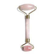 Cosmedix Rose Quartz Crystal Facial Roller, rozenkwarts gezichtsroller met gouden details voor effectieve gezichtsmassage.