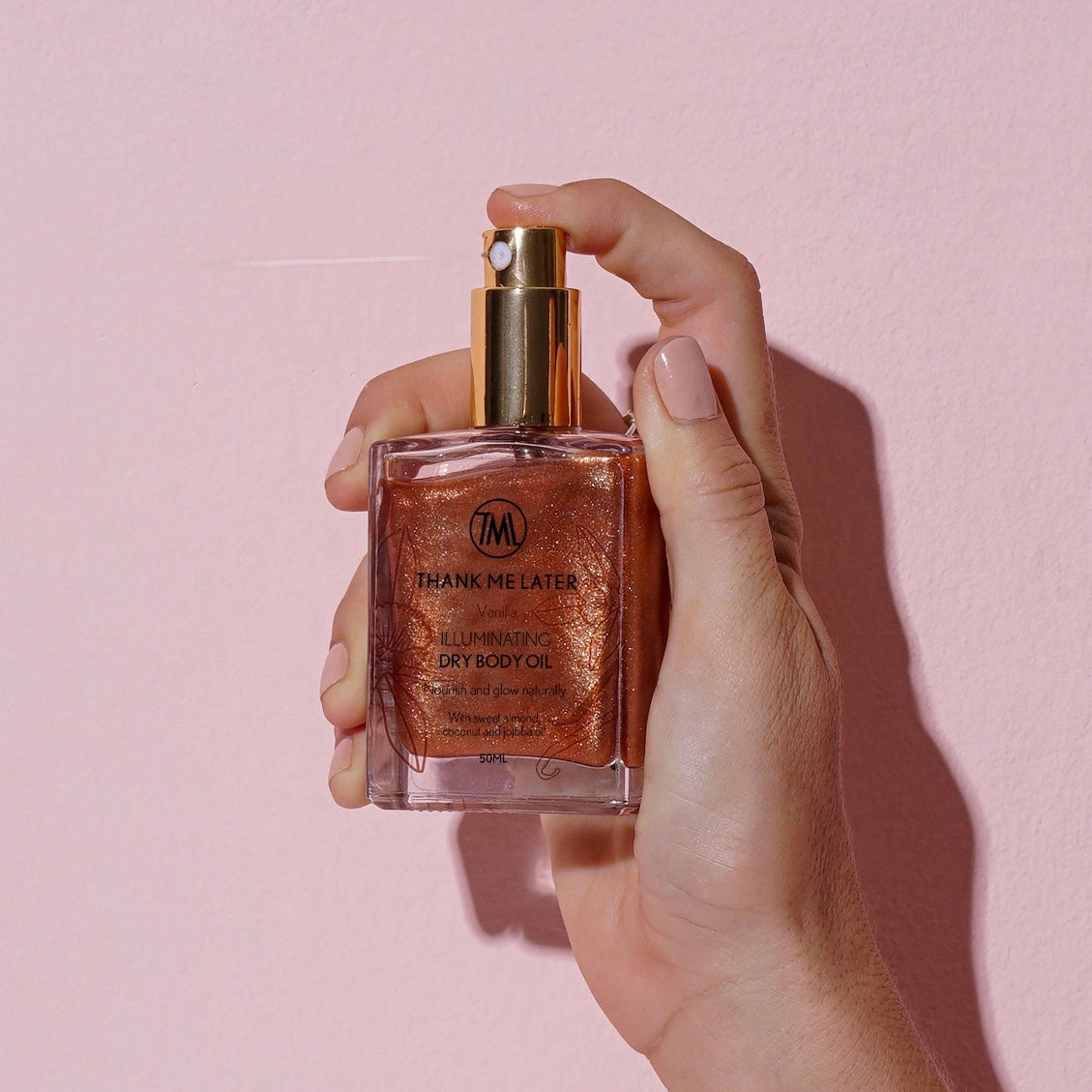 Thank Me Later Illuminating Dry Body Oil Vanilla 50ml in hand, showcasing its golden shimmer for radiant skin.