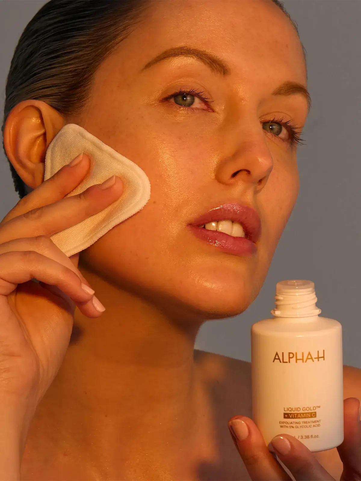 Alpha-H Liquid Gold + Vitamin C 100ml, vrouw gebruikt exfoliërende behandeling voor een stralende teint.