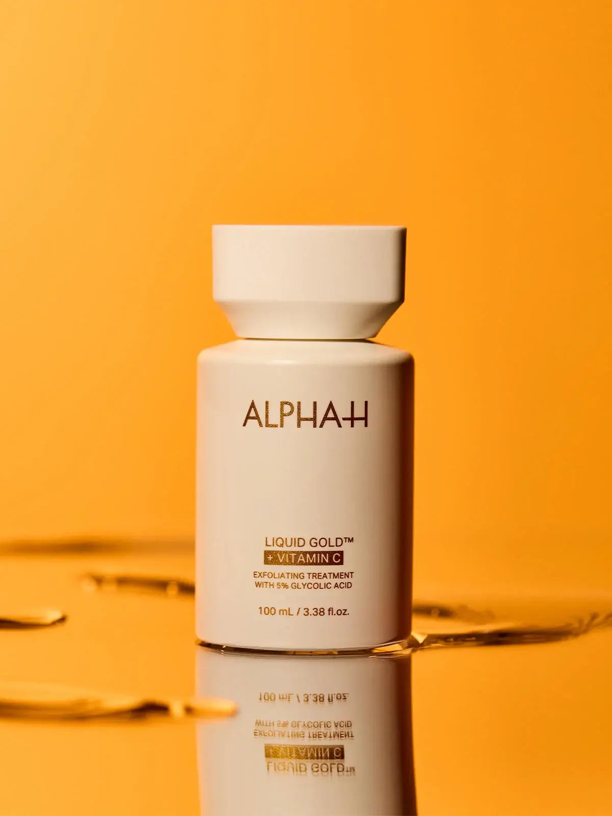 Alpha-H Liquid Gold + Vitamin C 100ml flesje met exfoliërende formule op een gouden achtergrond
