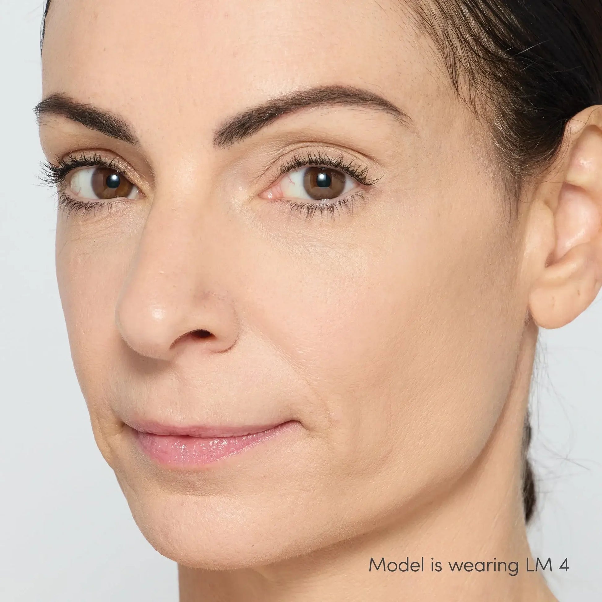 Jane Iredale Skintuition Brightening Under Eye Concealer LM4 op model met neutrale ondertoon, stralende huid zonder donkere kringen.