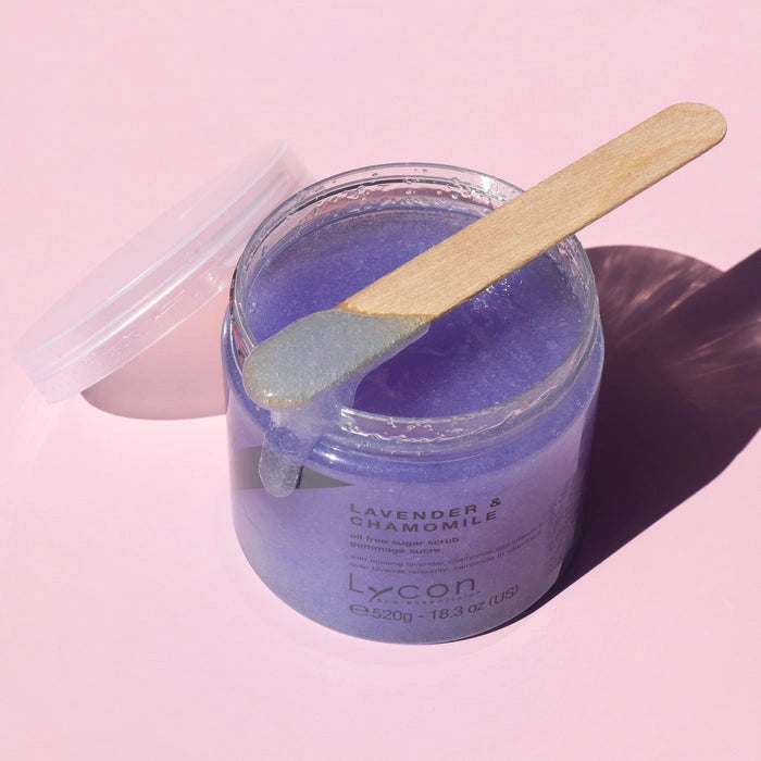 Lycon Lavender & Chamomile Sugar Scrub 520g in a jar with a wooden spatula, showcasing a calming lavender color and smooth texture.