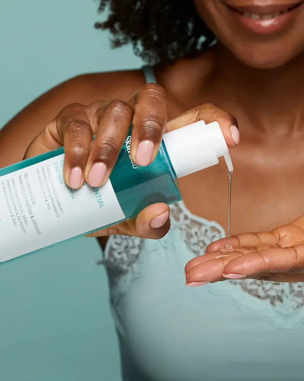 Sensilis Purify Essential Cleanser 400ml, vrouw die cleanser in handpalm verwerkt voor vette huid, lichte geltextuur.