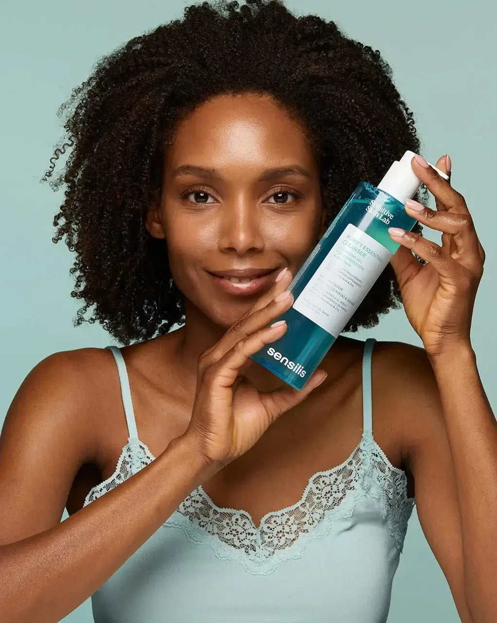 Sensilis Purify Essential Cleanser 400ml in gebruik met een model dat stralend en verzorgd eruitziet.