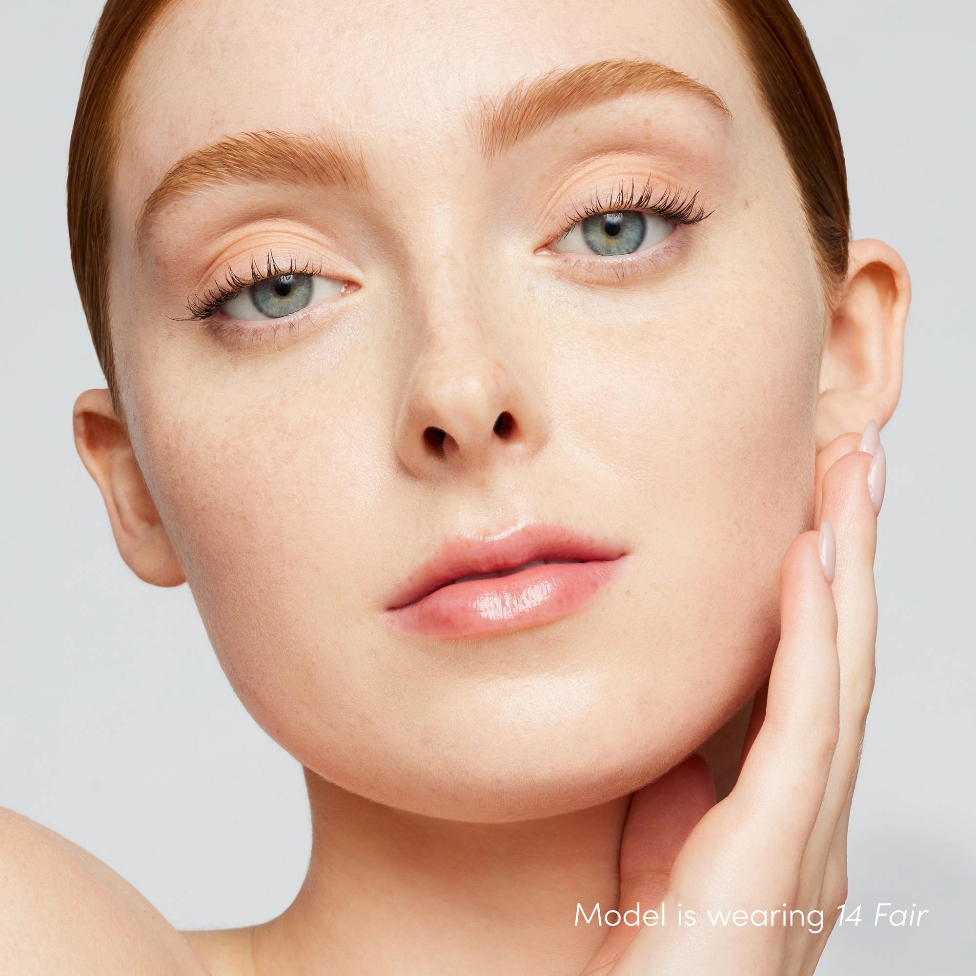 Jane Iredale Skintuition SPF30 Radiance-Boosting Liquid Foundation 14 Fair 30ml op model met lichte huid en koele roze ondertoon.
