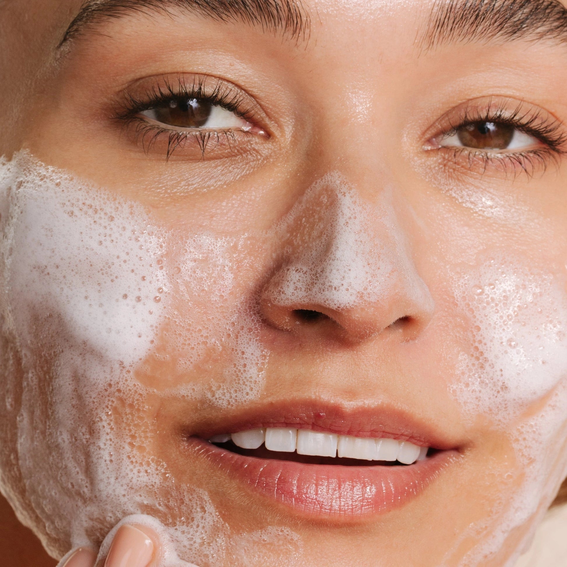 Dermalogica Breakout Clearing Kit 110ml: vrouw die reinigingsschuim aanbrengt voor effectieve acnebestrijding.